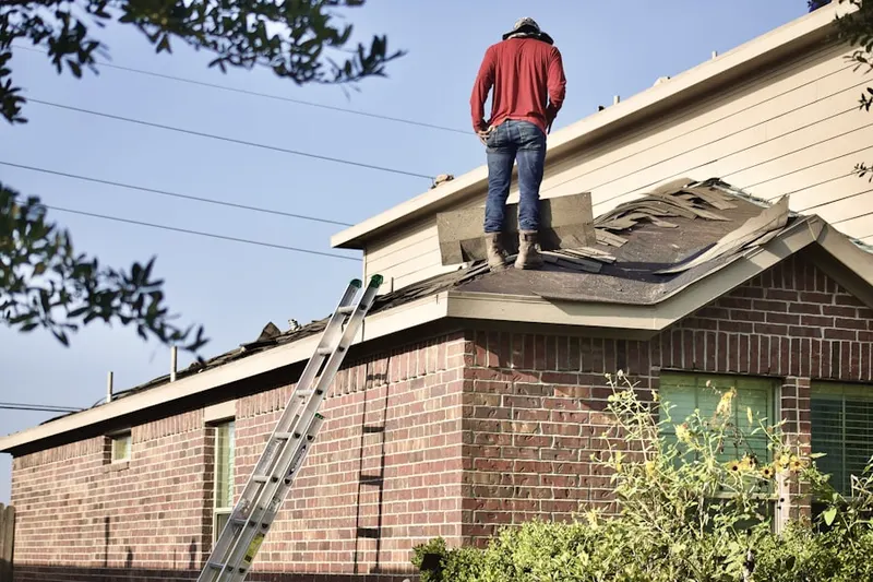 Professional roofer working on a residential roof in Guilford